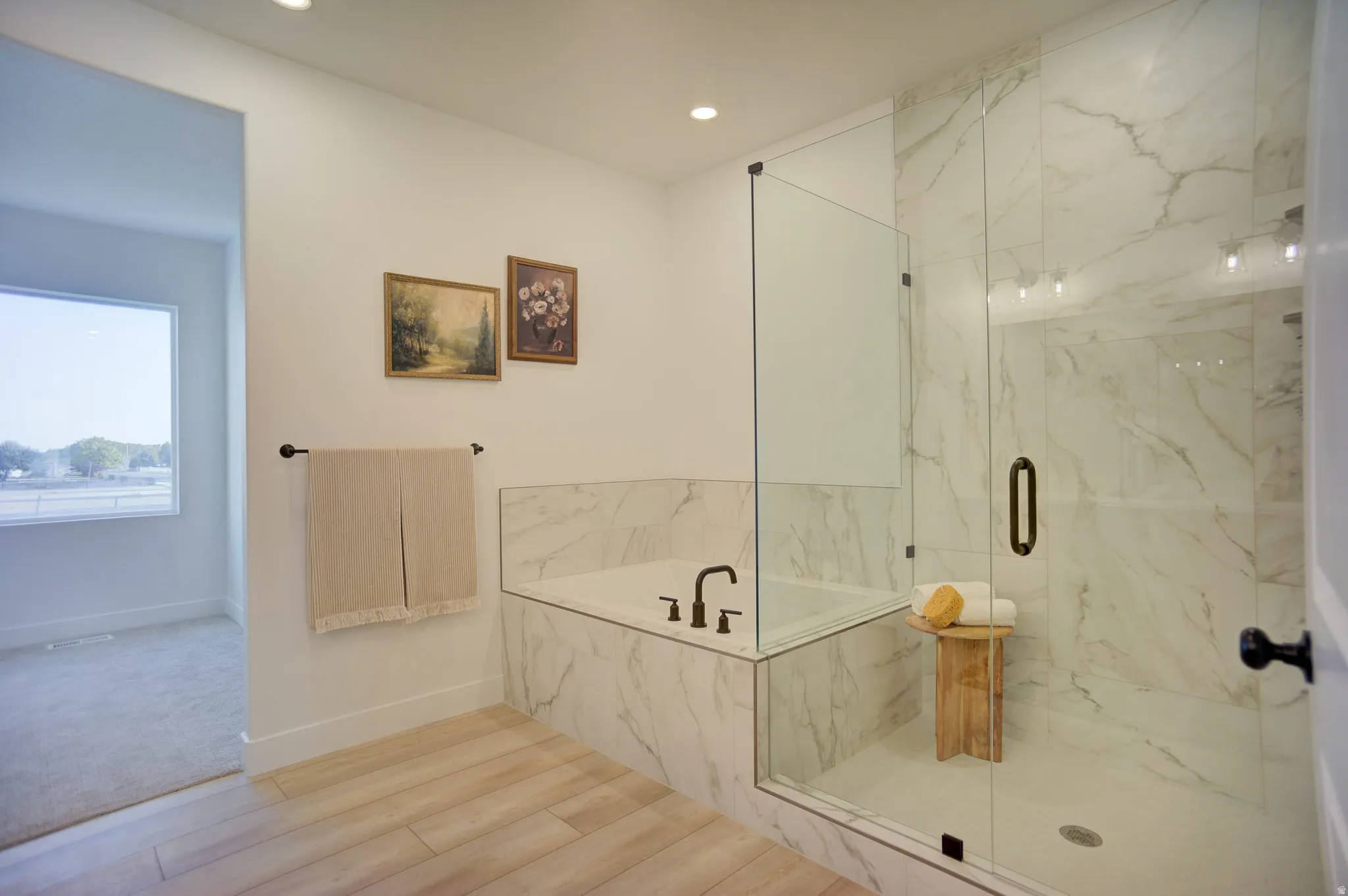 Full bathroom with a marble finish shower, a bath, light wood-style floors, and recessed lighting