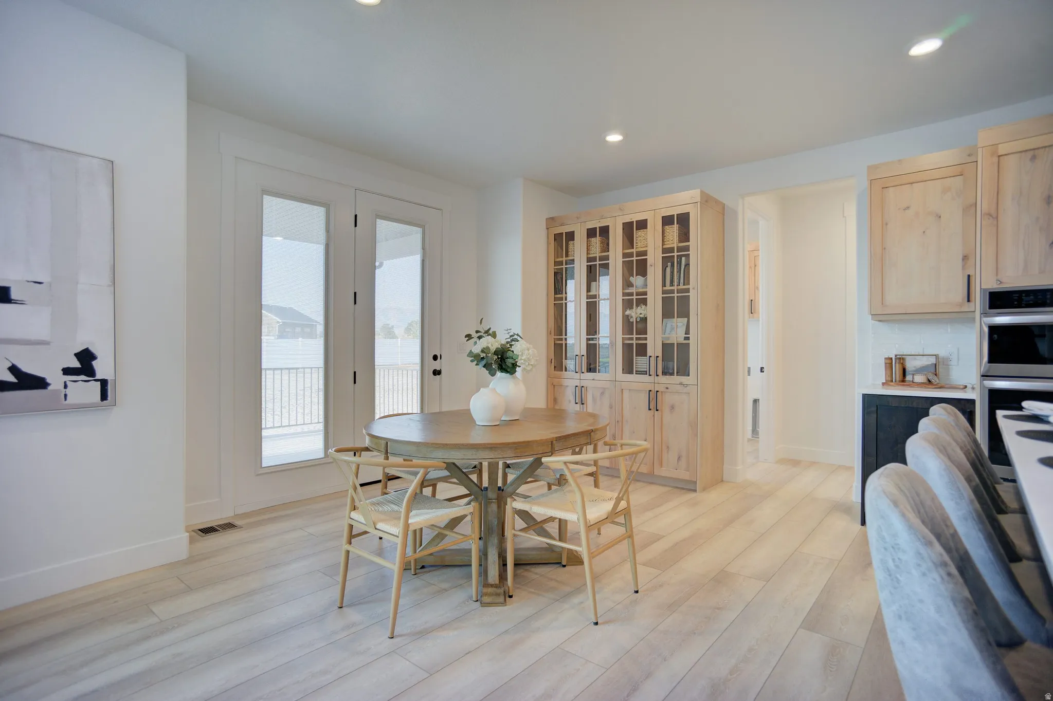 Dining room with light wood-style flooring and recessed lighting