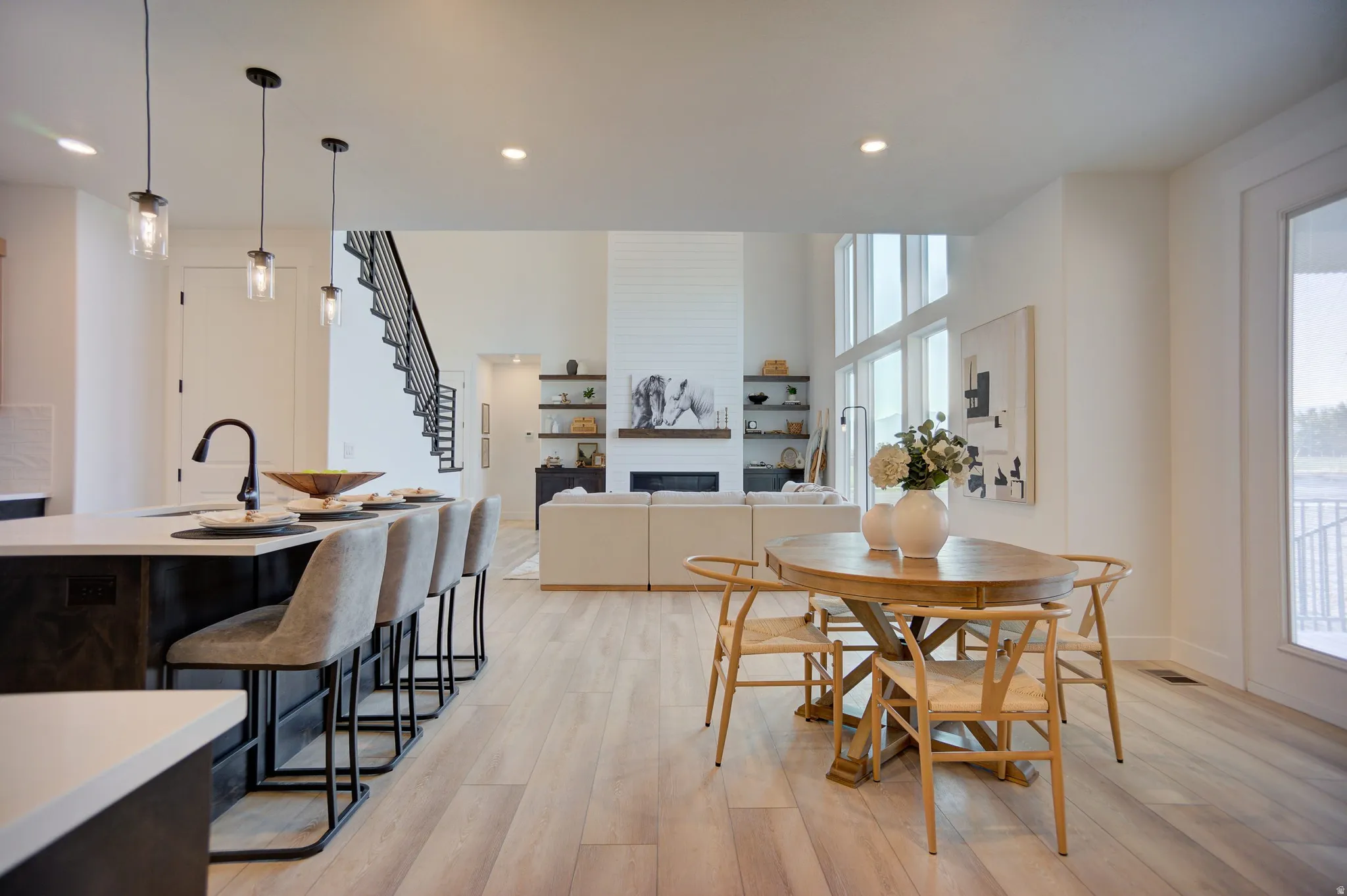 Dining area featuring light wood-style flooring, a large fireplace, and recessed lighting