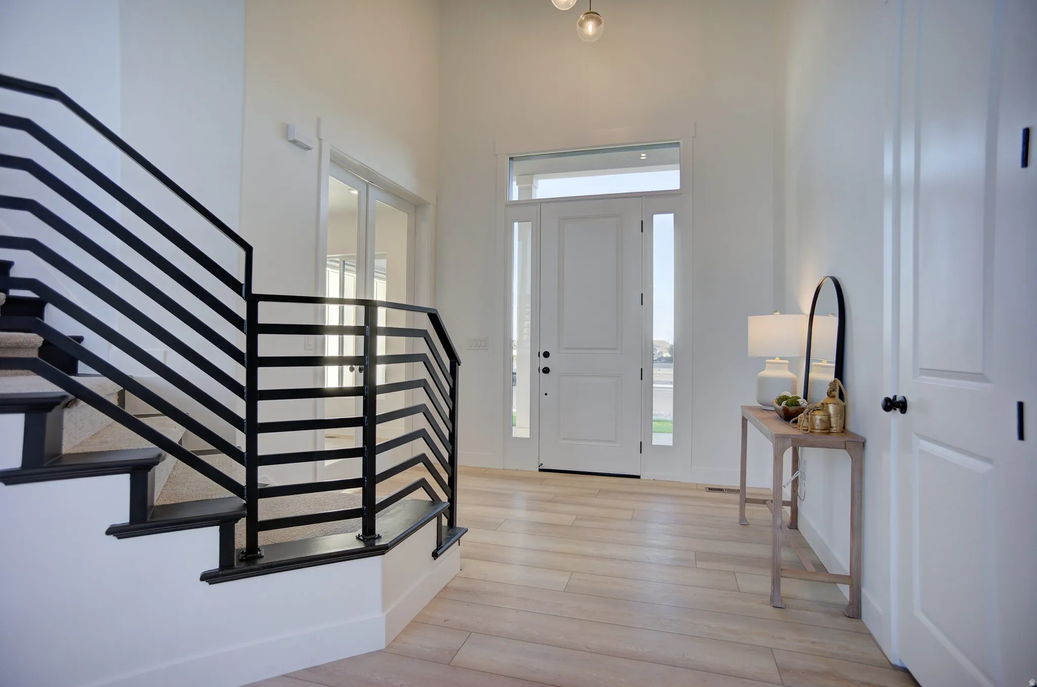 Foyer entrance featuring stairs and light wood-style floors