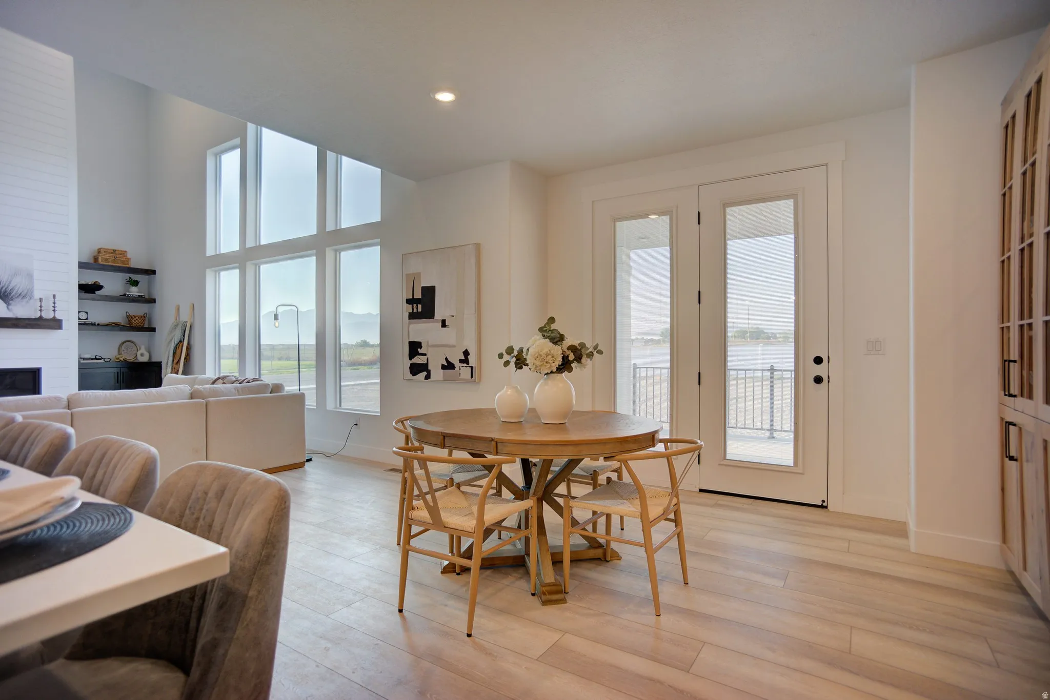 Dining area featuring light wood-style floors, recessed lighting, a high ceiling, and a fireplace