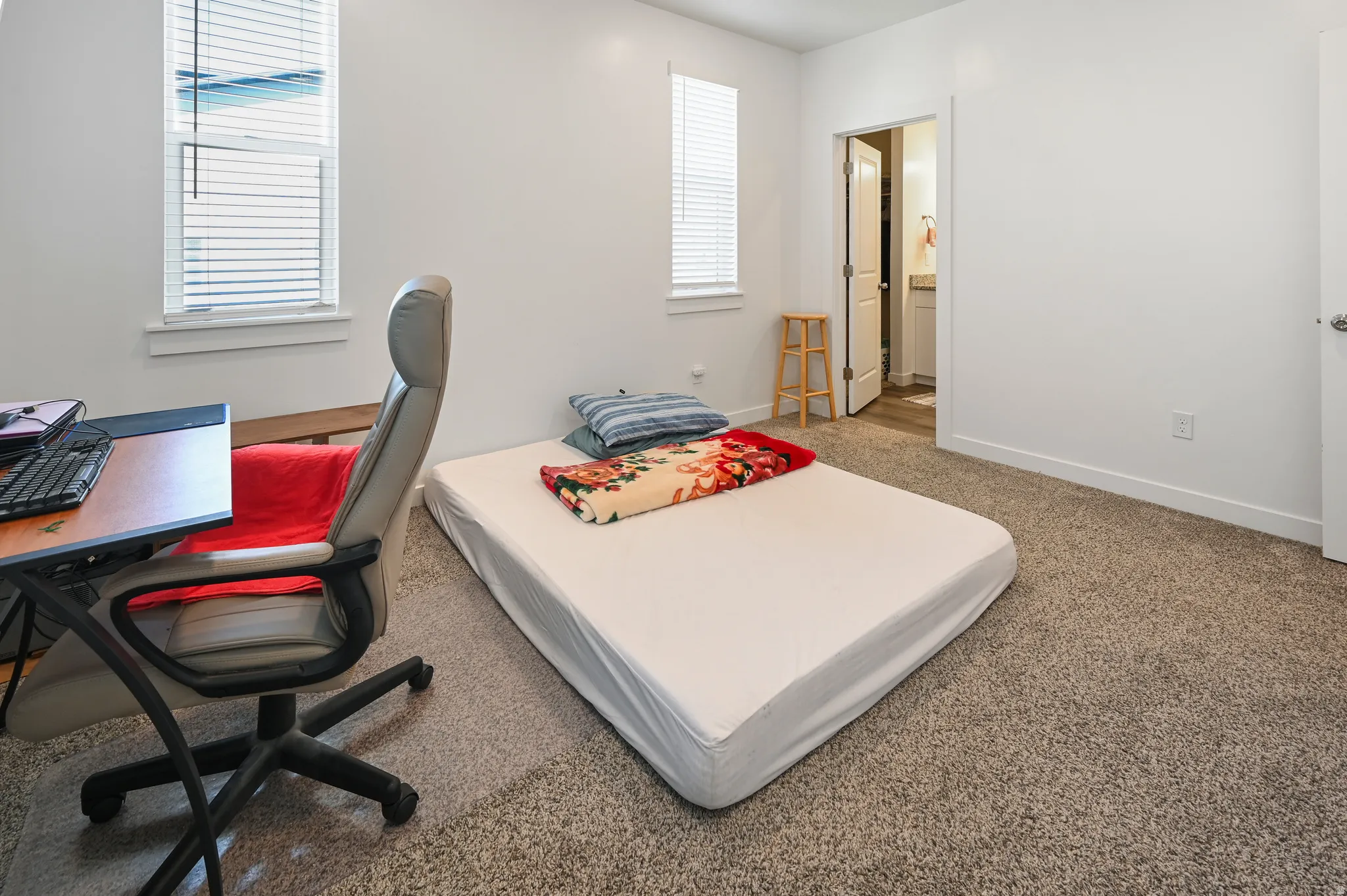 Bedroom with an office area, carpet, and ensuite bathroom