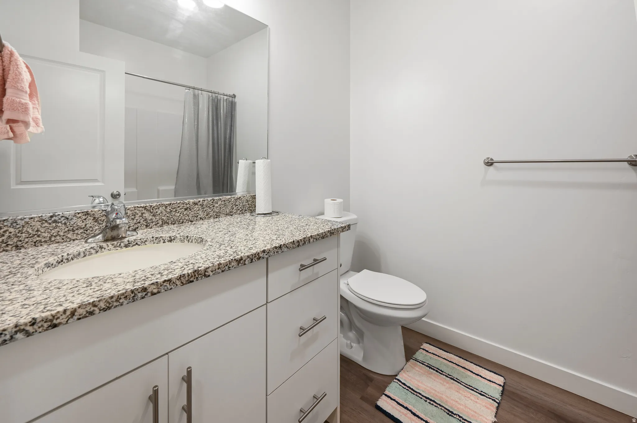 Bathroom featuring vanity, a shower with shower curtain, and dark wood-style floors
