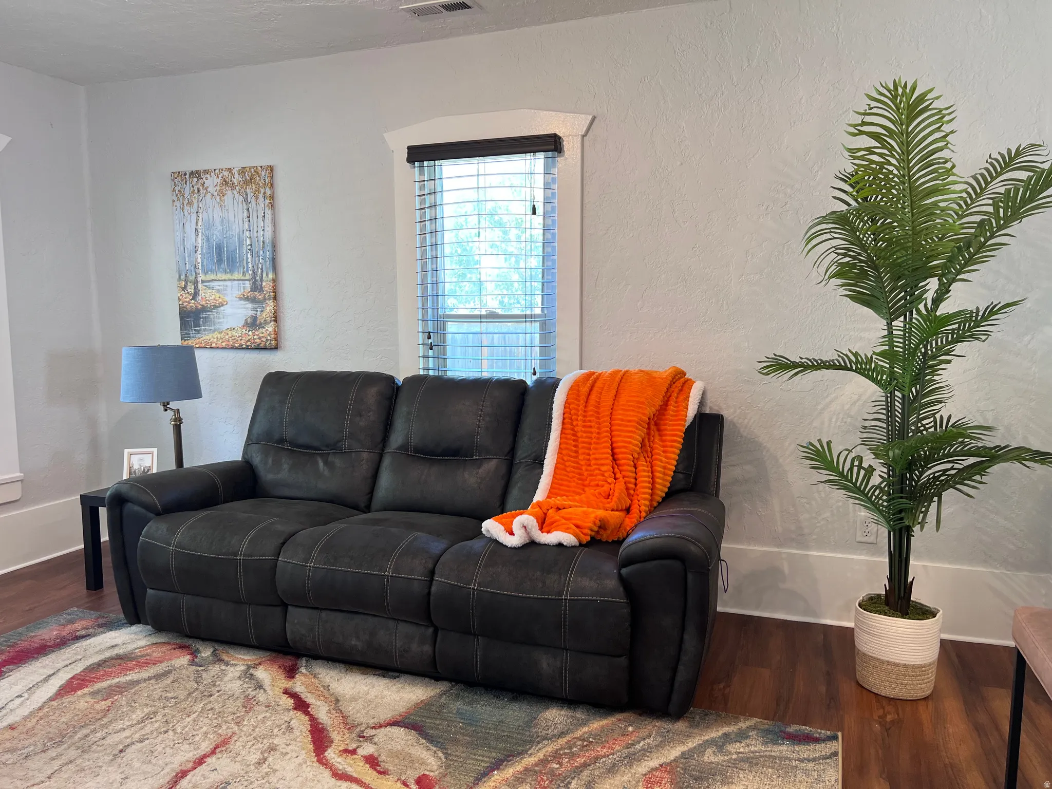 Living room with wood finished floors and a textured wall