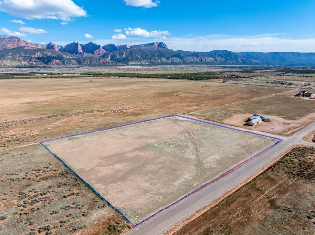 Overview of rural landscape with a mountainous background and property parcel outlined