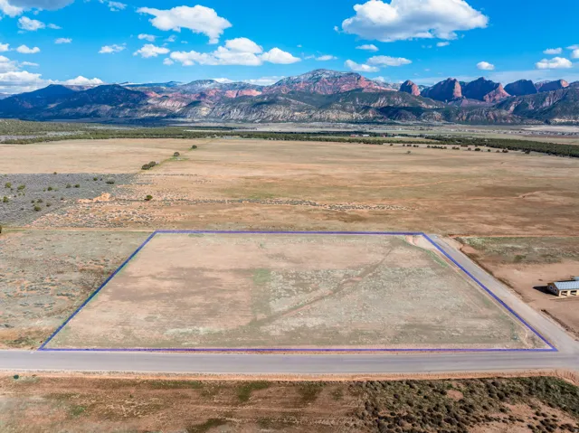 Overview of rural landscape with property parcel outlined and mountains