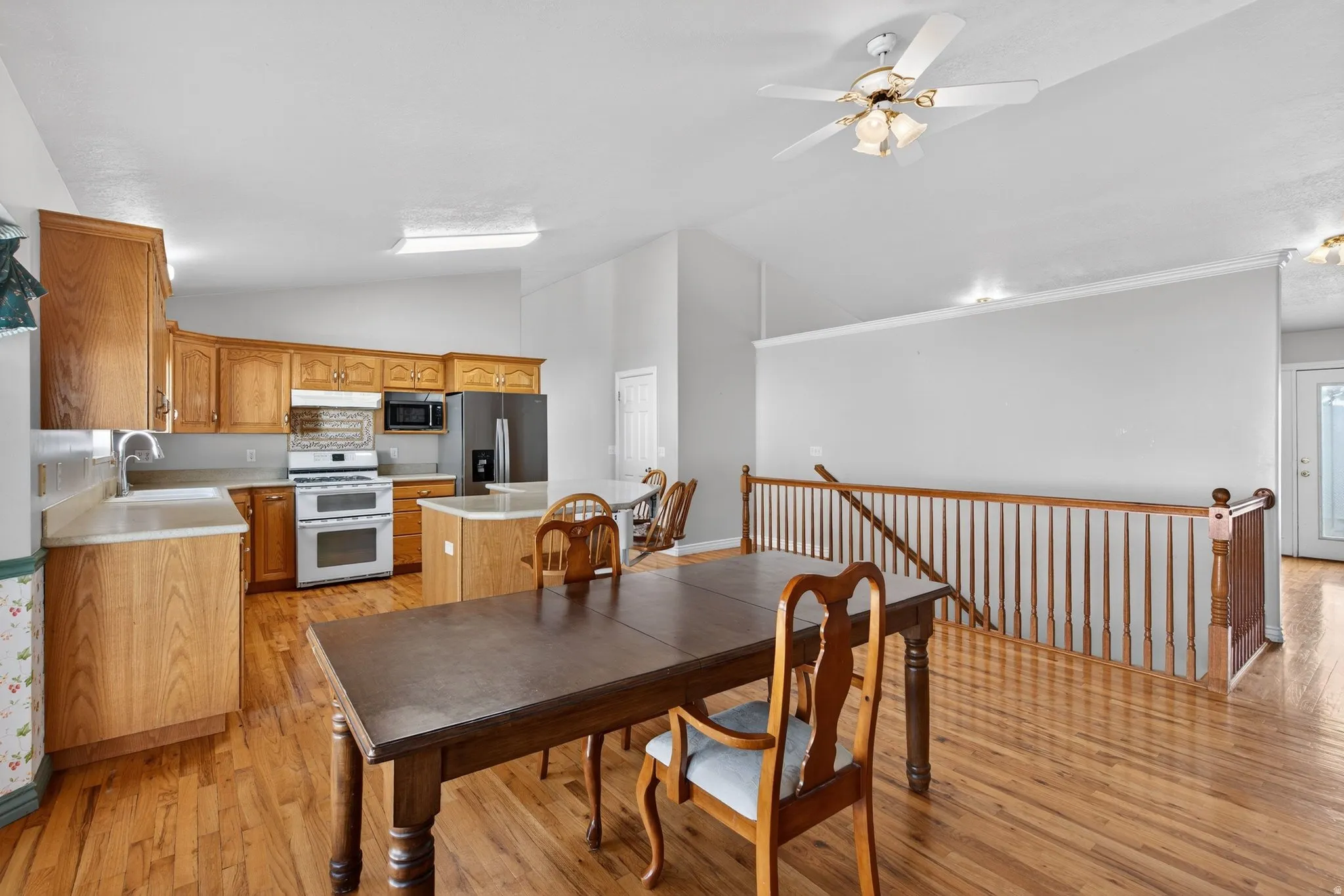 Dining space with light wood-type flooring, a ceiling fan, and lofted ceiling