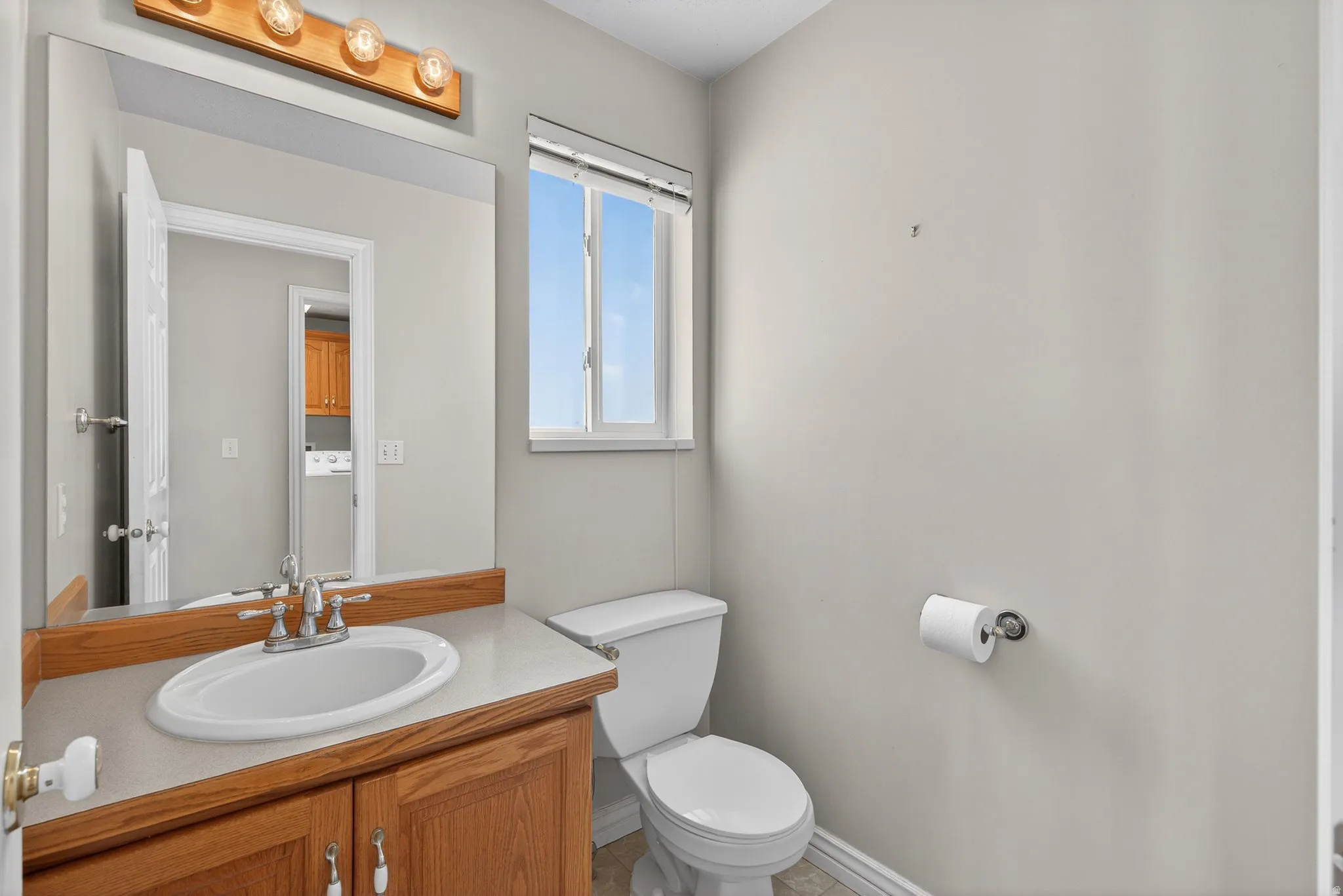Half bath with vanity and washer / dryer off the garage entrance