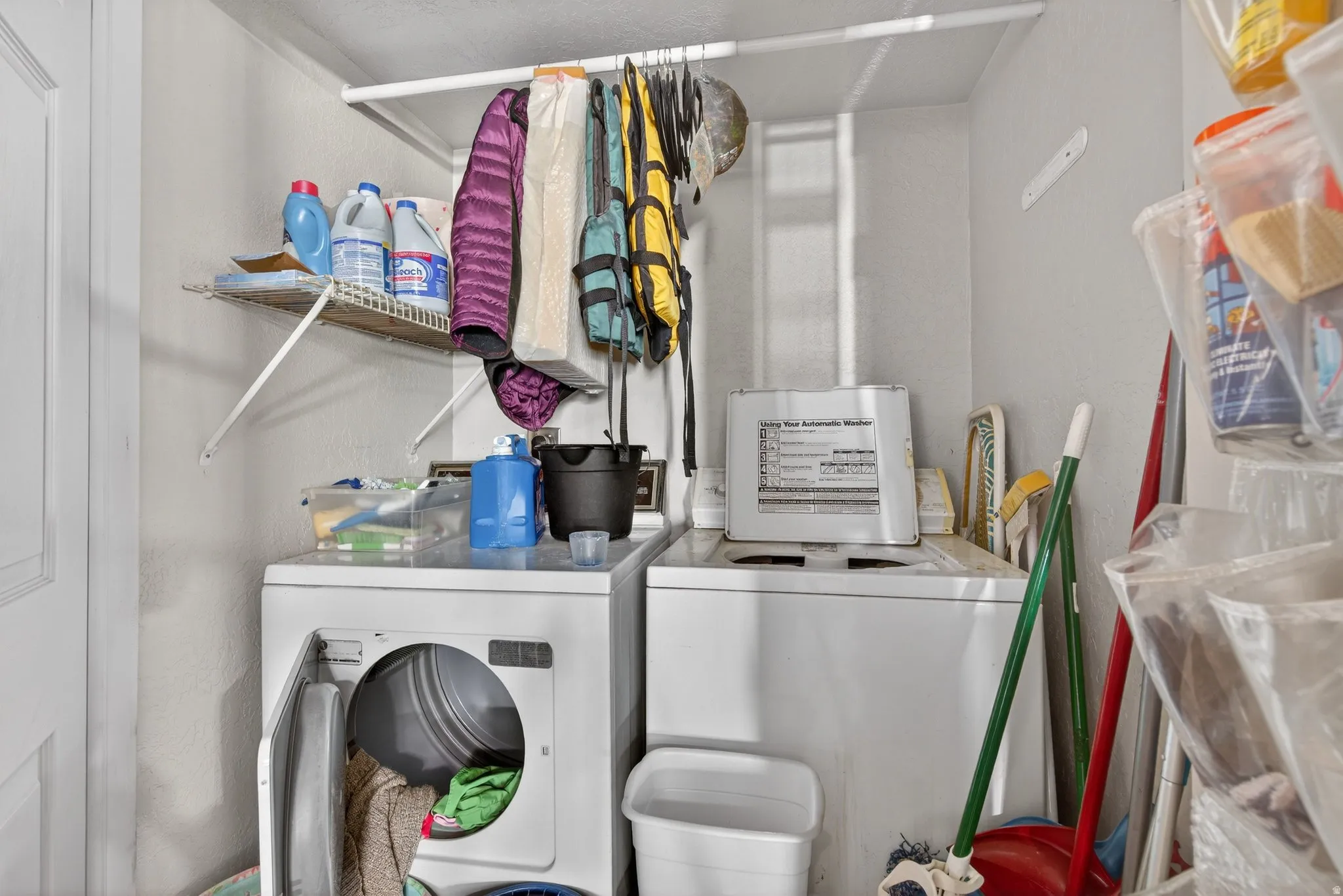 Laundry area in ADU featuring separate washer and dryer and a textured wall