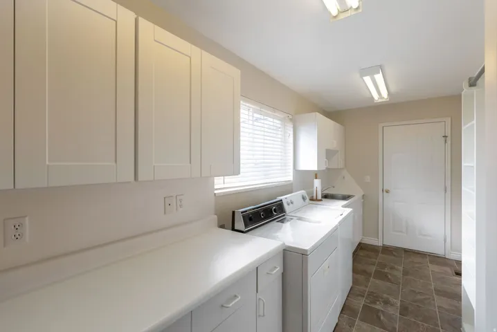 Laundry area with separate washer/dryer and cabinet space