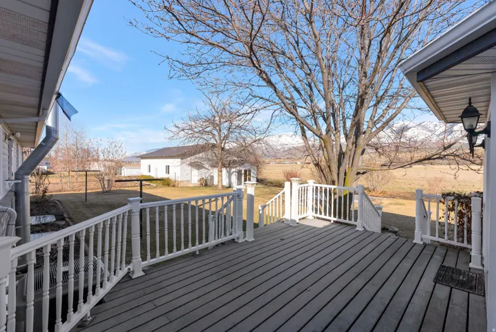 Wooden terrace featuring an outdoor structure, a yard, and a residential view
