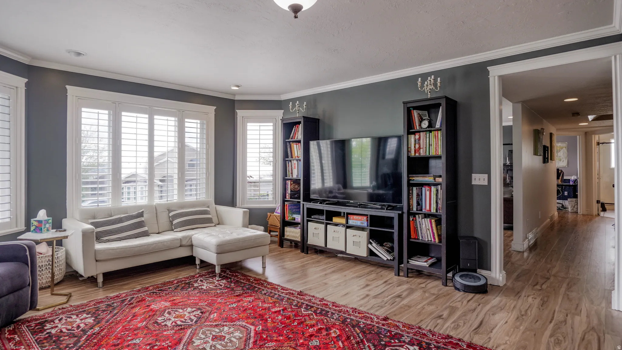 Living room with wood finished floors and ornamental molding