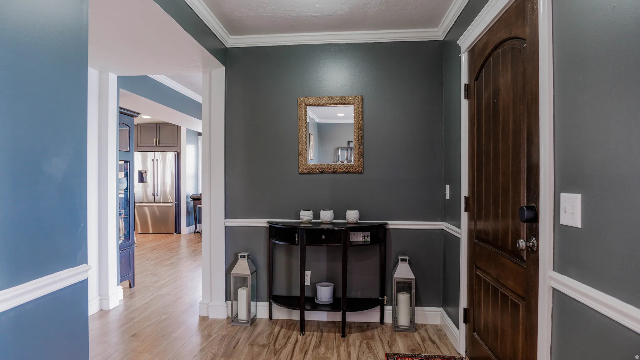 Foyer featuring crown molding and light wood-type flooring