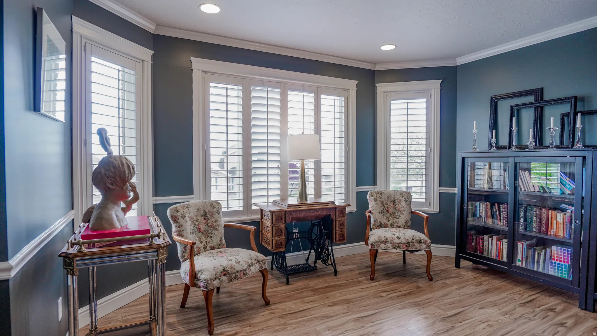 Living area with light wood finished floors, ornamental molding, and recessed lighting
