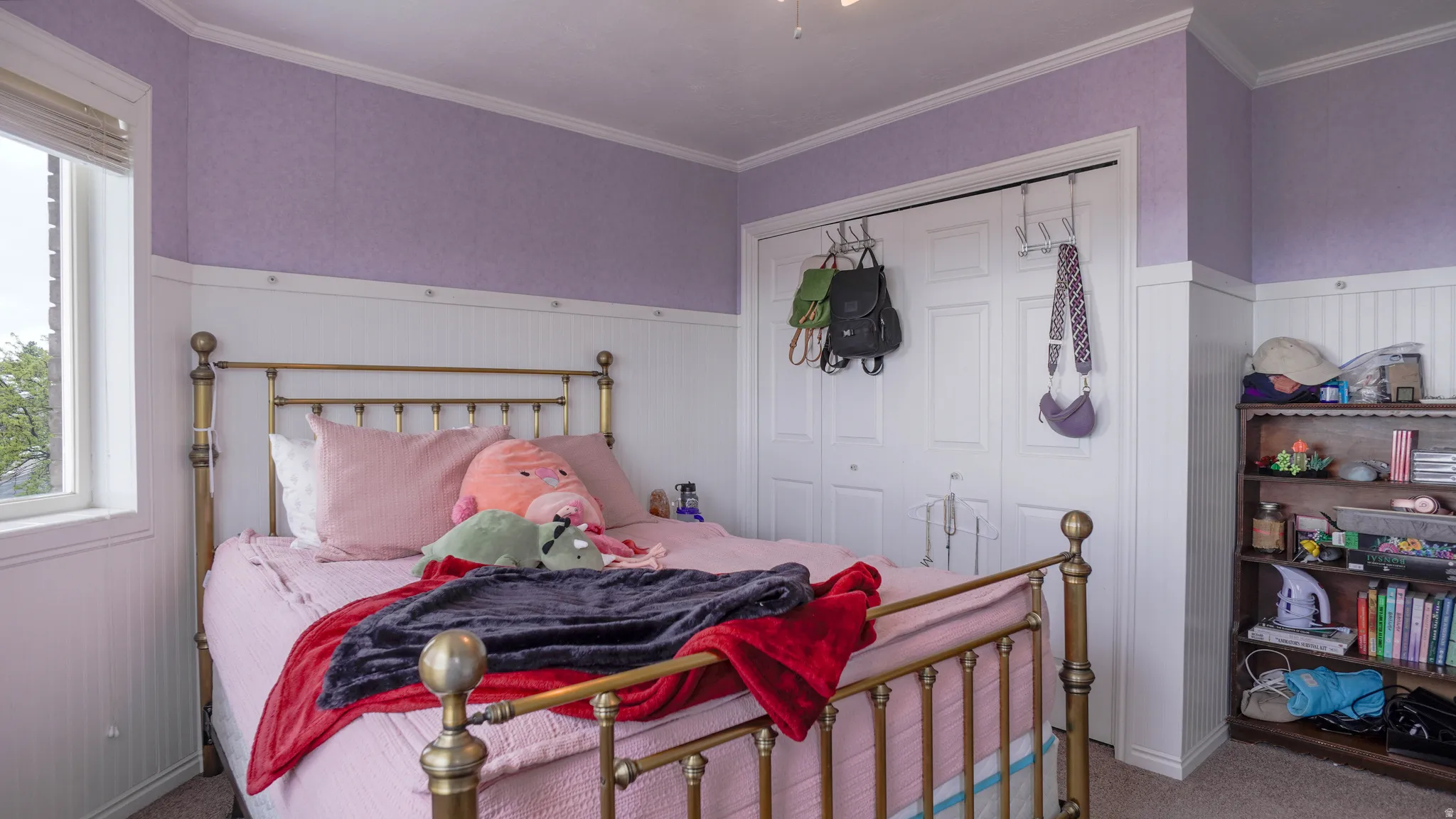Bedroom featuring carpet, ornamental molding, a closet, and a wainscoted wall