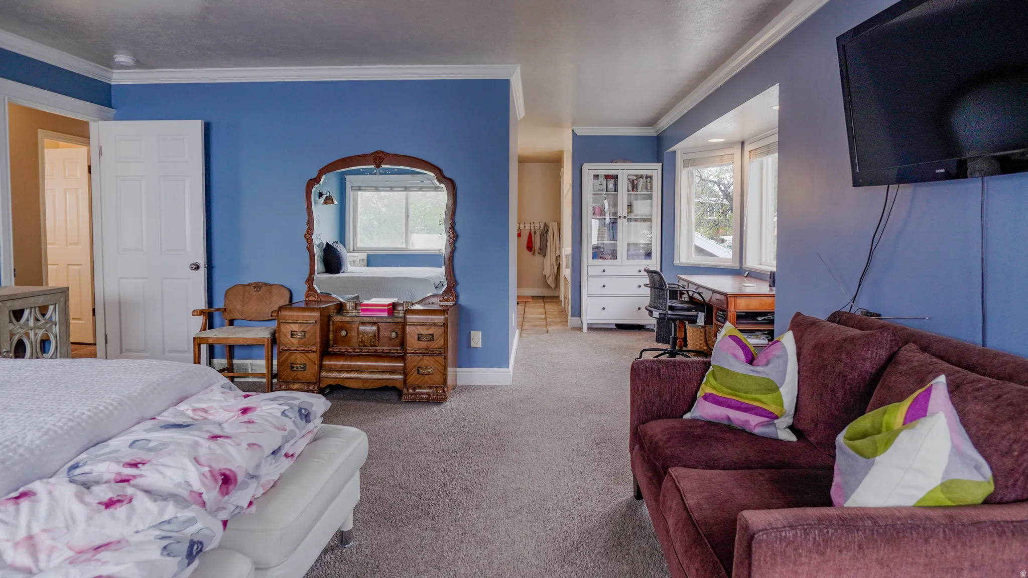 Large Primary Bedroom featuring Lots of Natural Light and crown molding