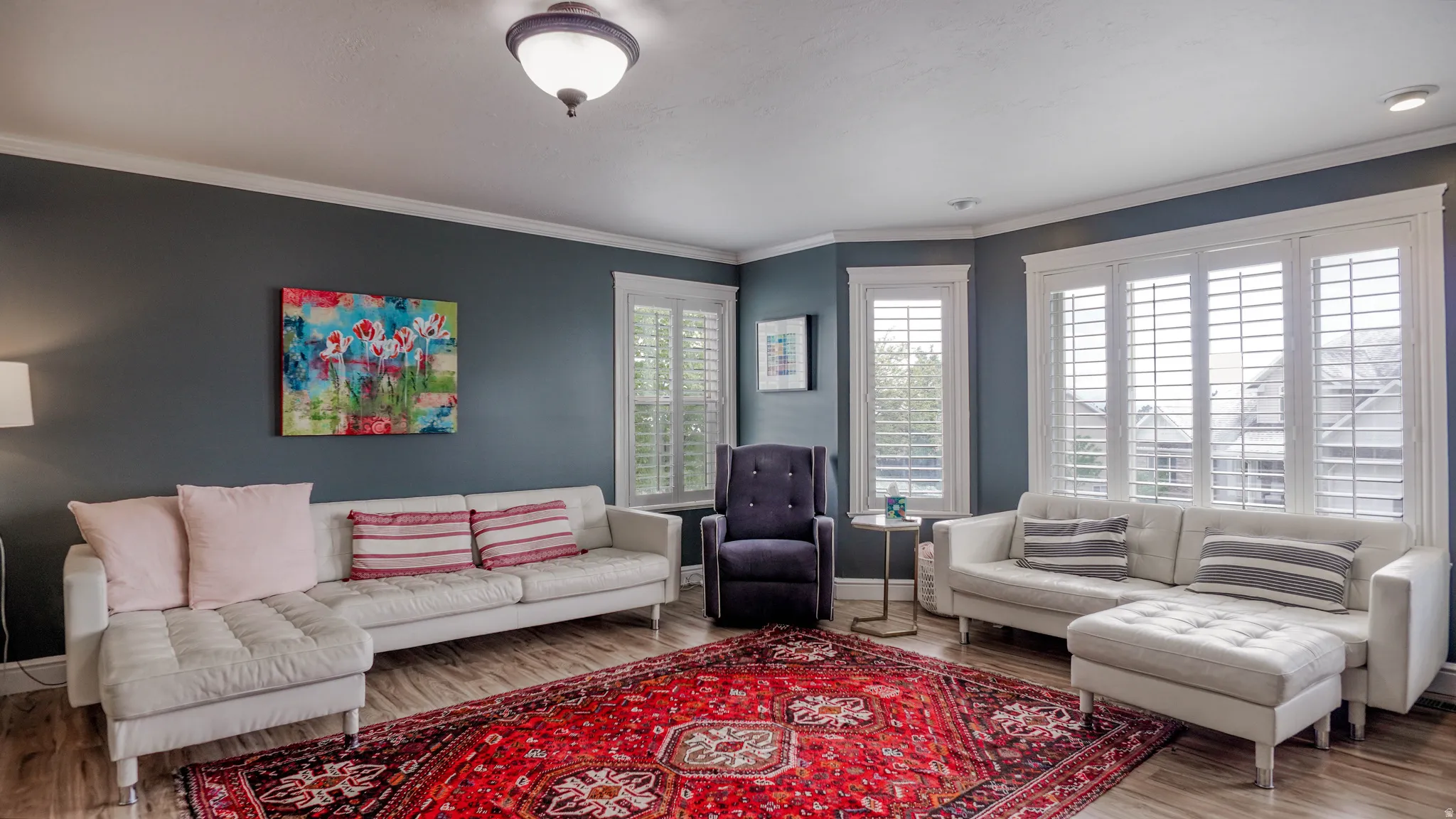 Living area featuring wood finished floors and ornamental molding