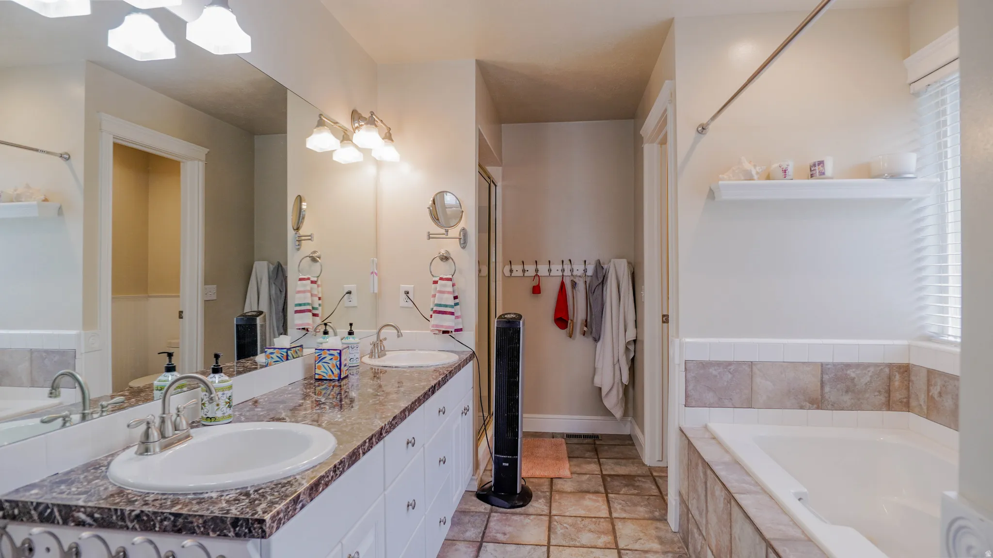 Full bathroom featuring a bath, double vanity, and Separate Shower