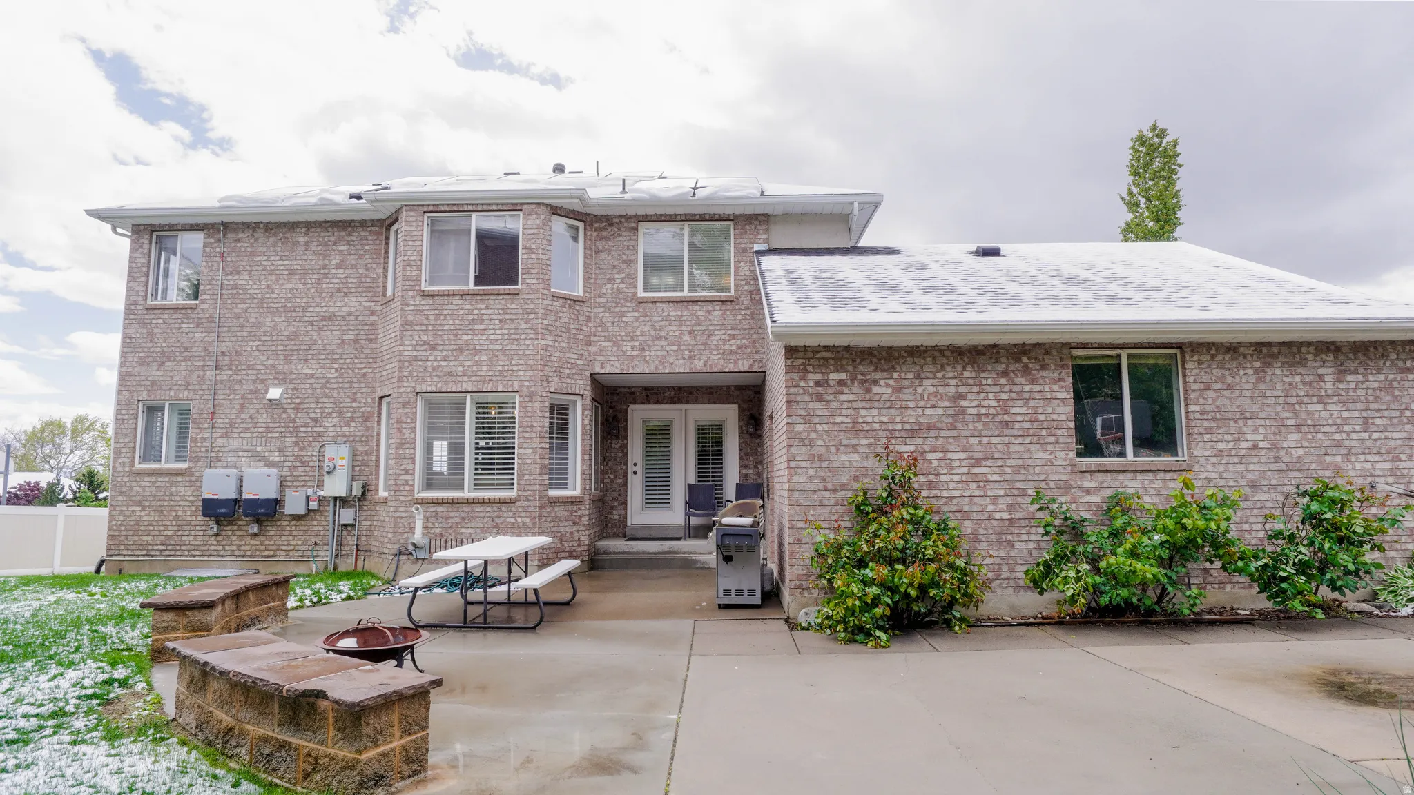 Back of house with an outdoor fire pit, a patio, and brick siding