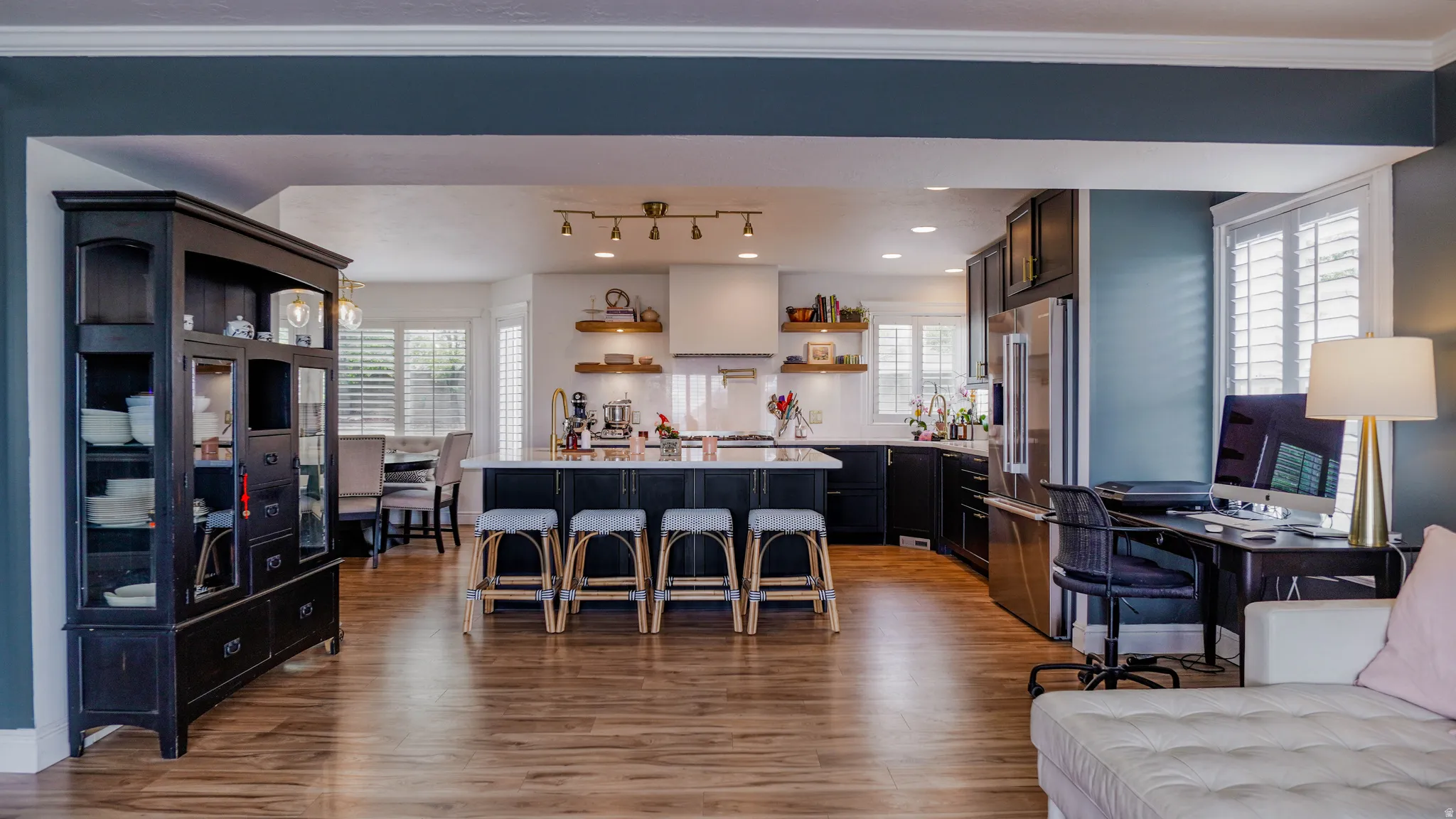 Living area featuring healthy amount of natural light, light wood-style flooring, crown molding, and an office area