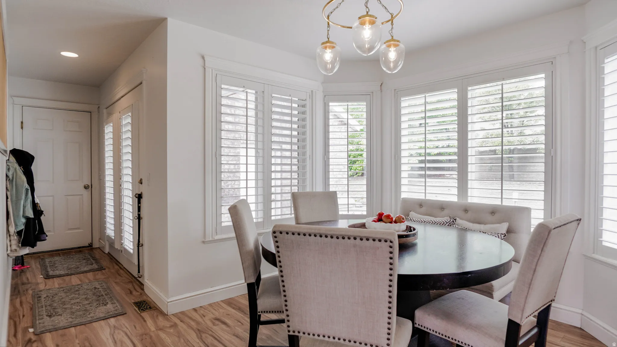 Dining room with a chandelier, light wood-type flooring, and healthy amount of natural light
