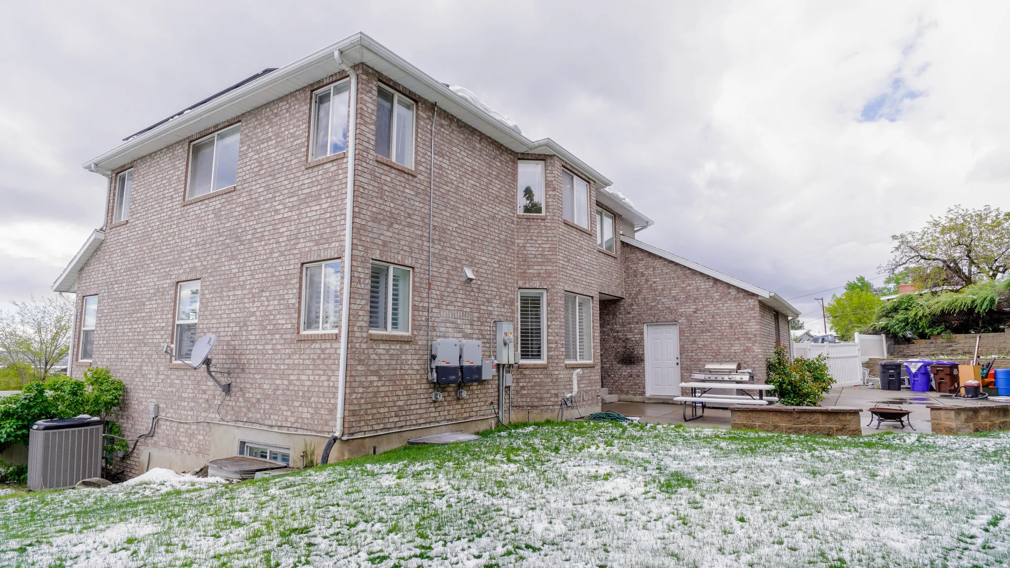 Rear view of property with a patio, brick siding, and an outdoor fire pit
