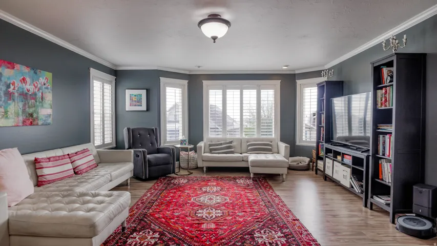 Living area featuring light wood finished floors and crown molding