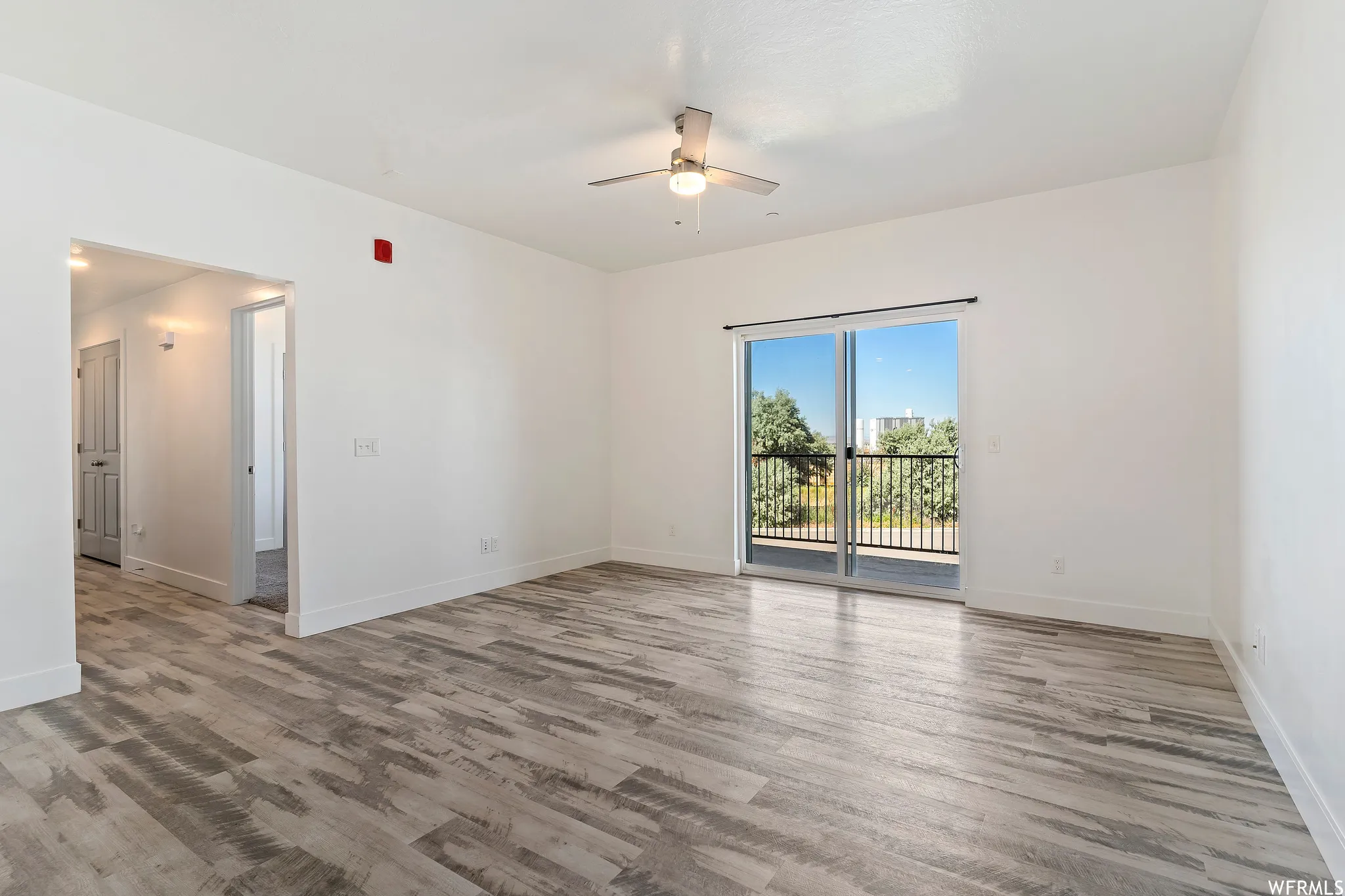 Unfurnished room with ceiling fan and light wood-style floors