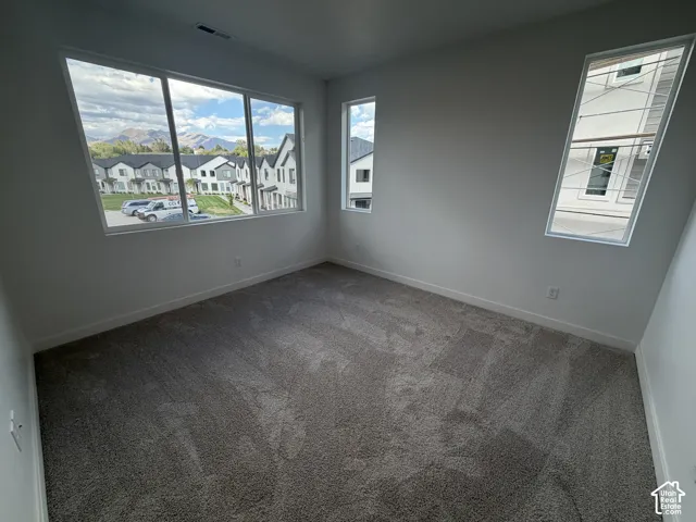 Spacious room with gray carpet and white walls