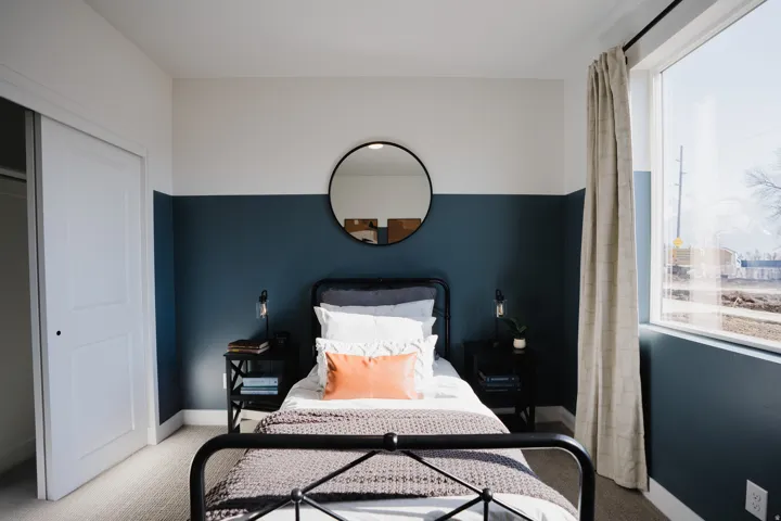 Bedroom with light carpet, multiple windows, and a closet