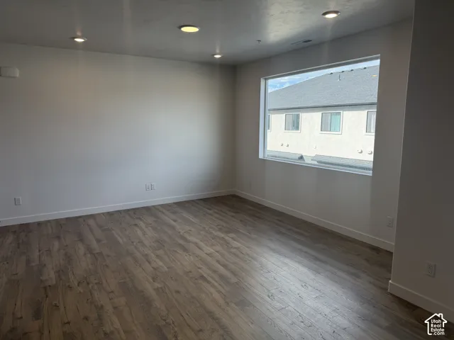 Recessed ceiling lighting, wood-finish flooring, and a large horizontal window