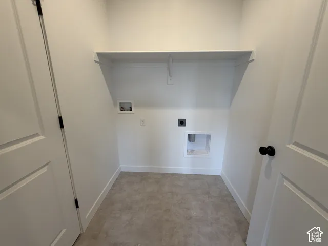Recessed laundry area featuring a built-in shelf and tile flooring