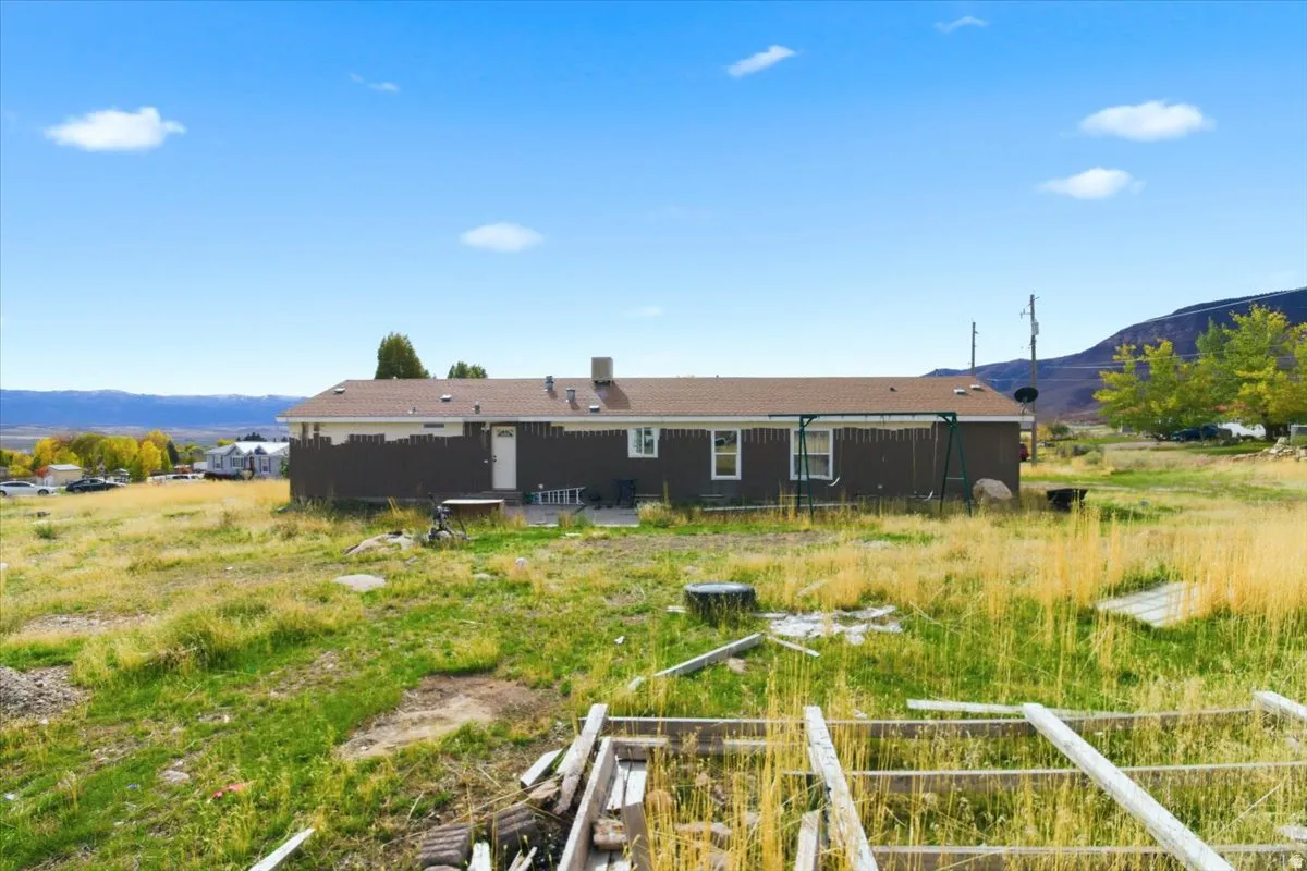 Back of property featuring a mountain view and a patio area