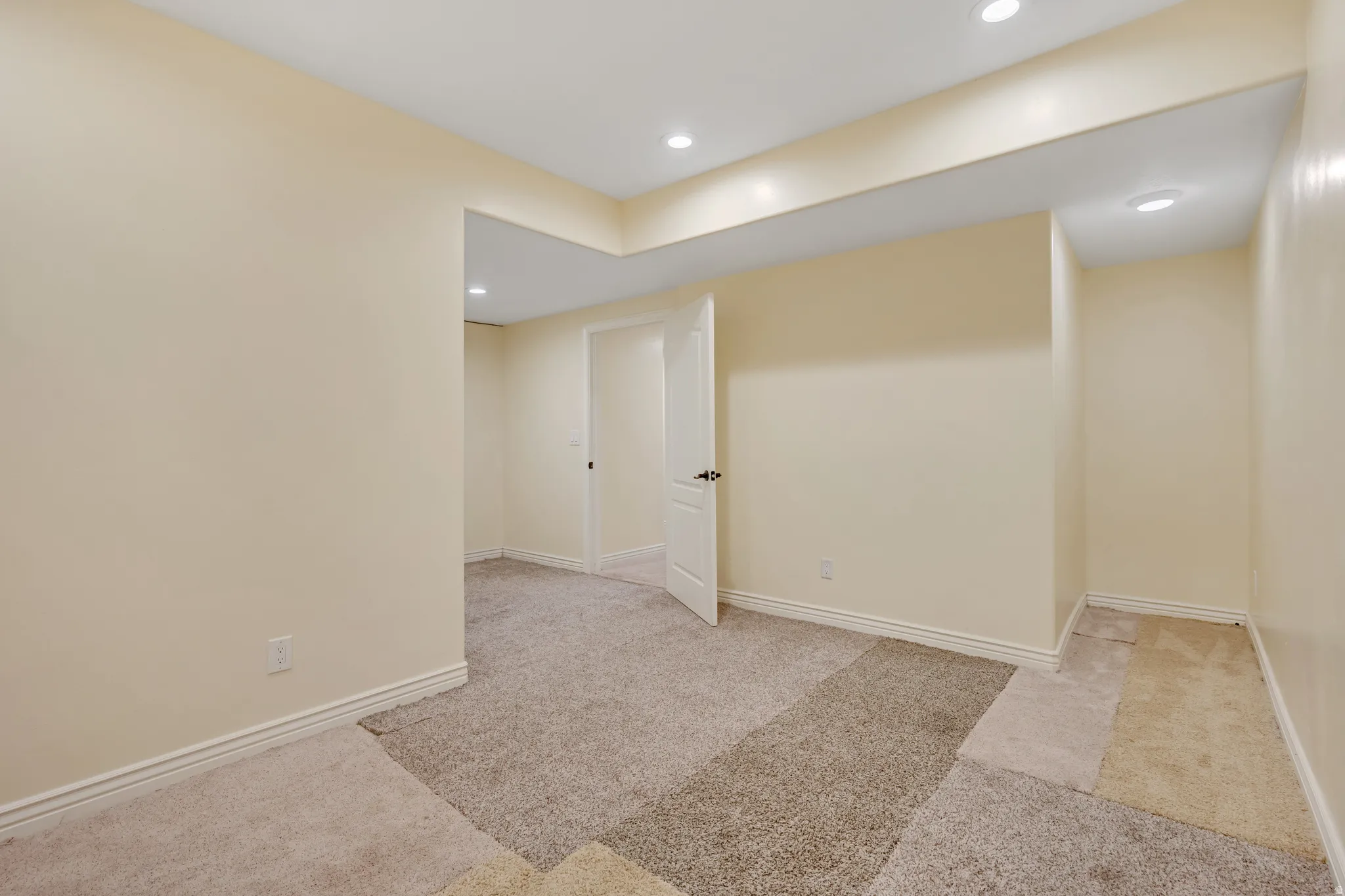 Below grade area with light colored carpet and recessed lighting