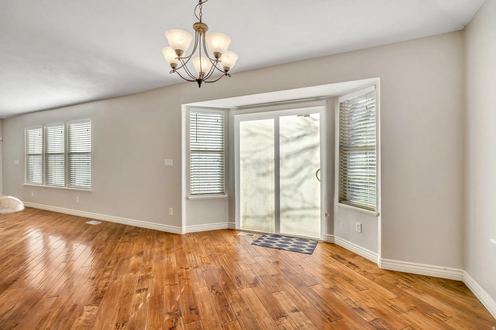 Unfurnished dining area with suspended lighting and light wood finished floors