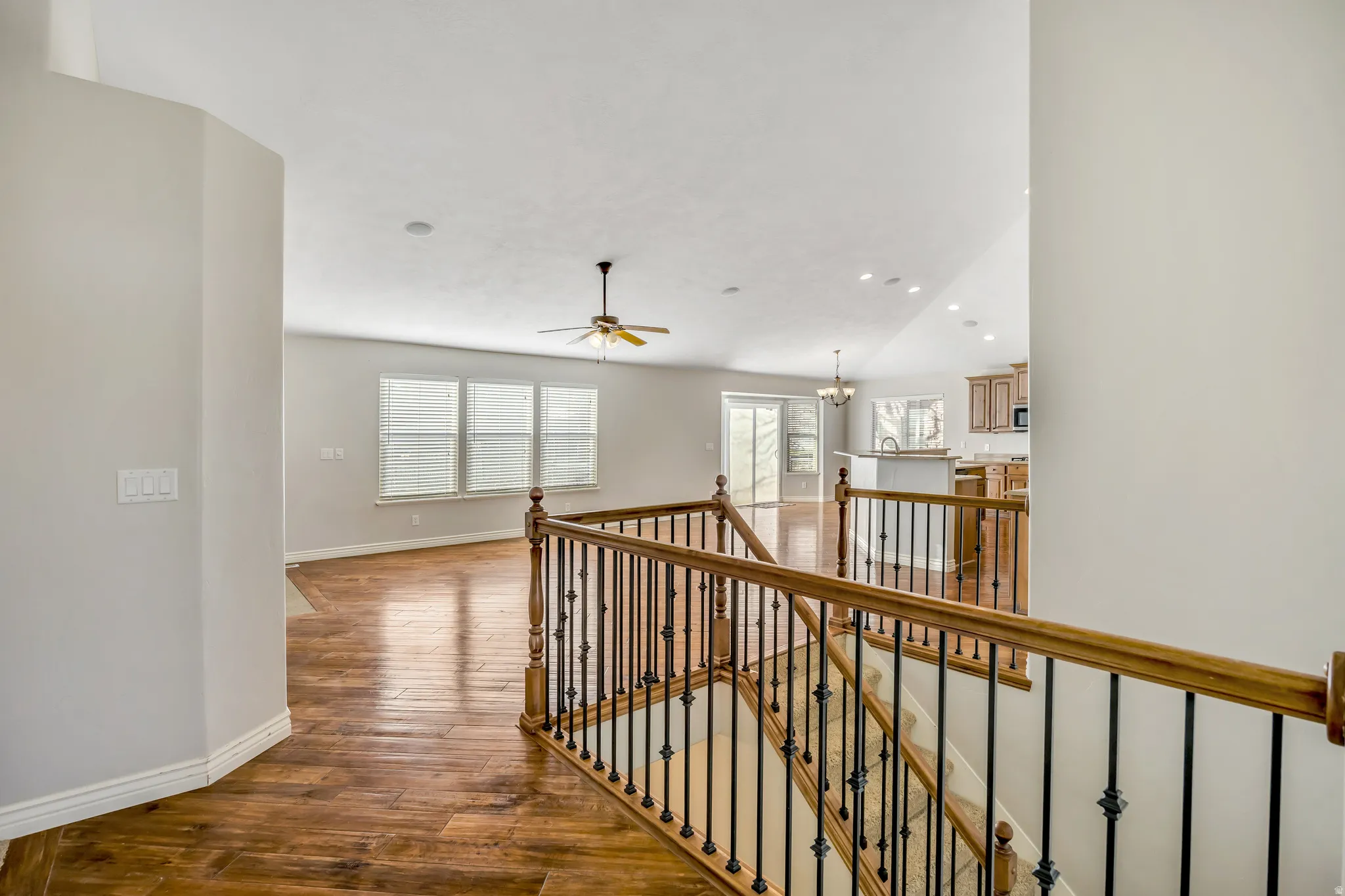 Corridor with an upstairs landing, dark wood-style floors, plenty of natural light, vaulted ceiling, and recessed lighting