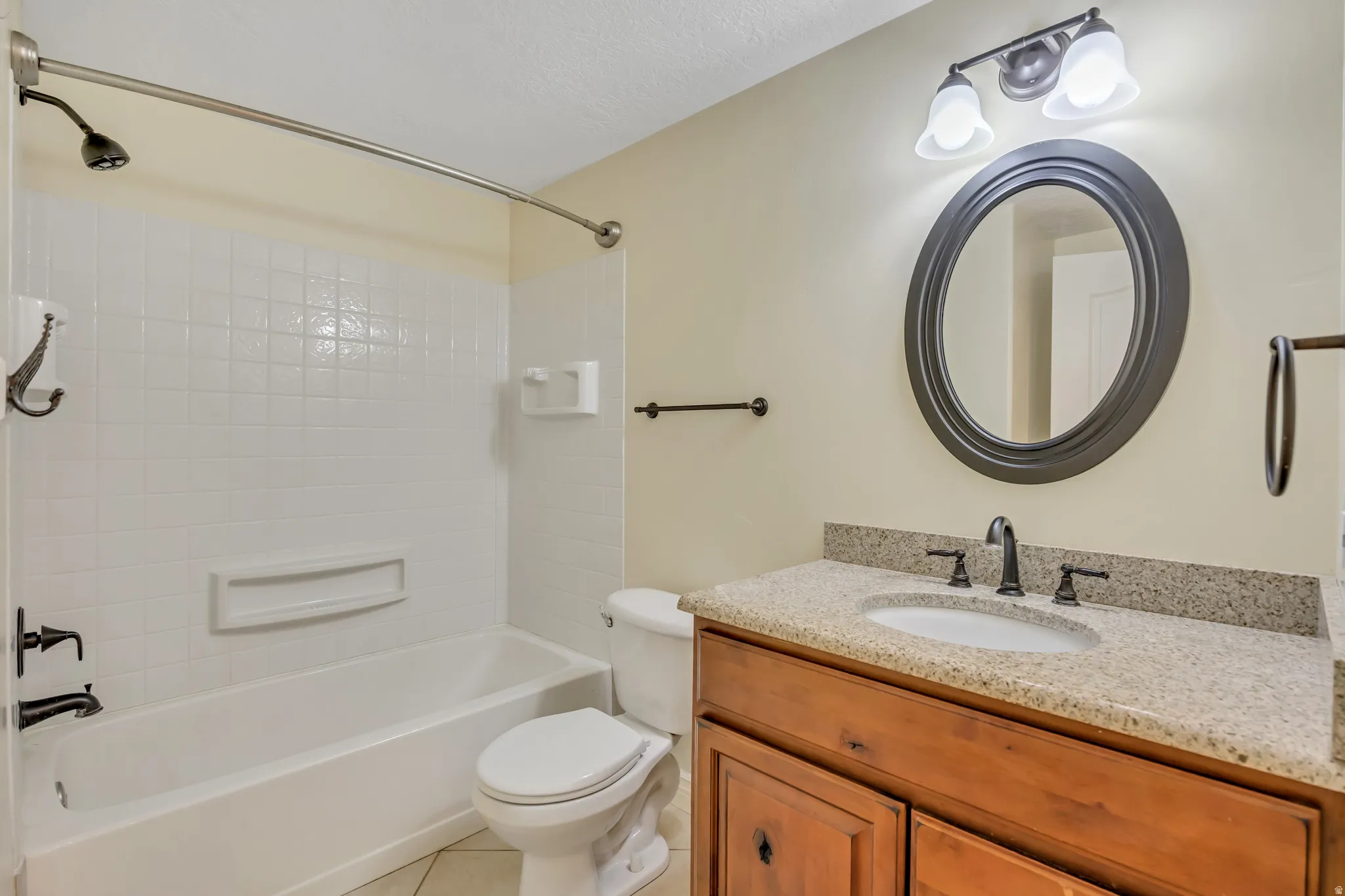 Full bath with vanity, light tile patterned floors, and bathtub / shower combination