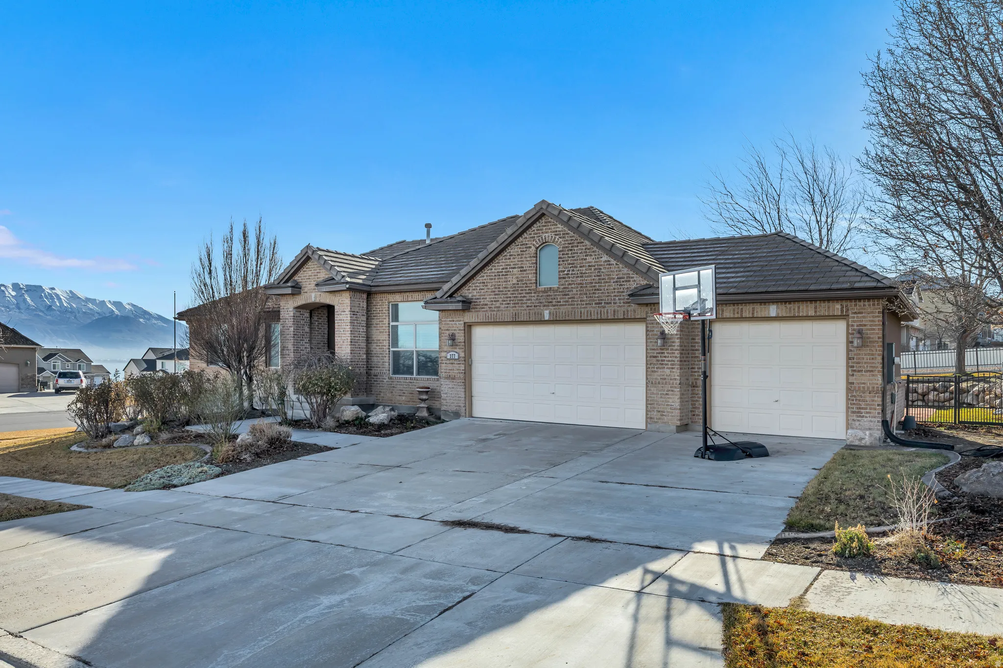 View of front of property with an attached garage, driveway, brick siding, and a mountain view