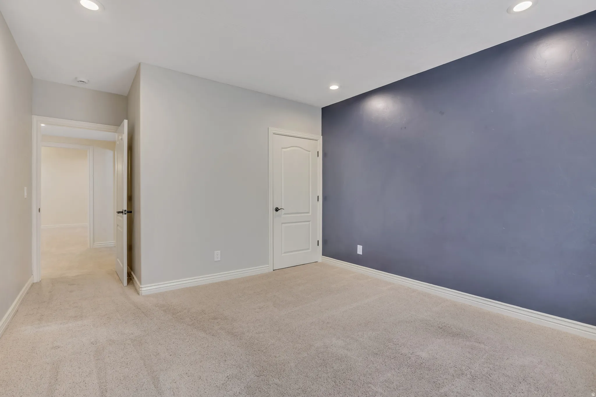 Unfurnished bedroom featuring light carpet and recessed lighting