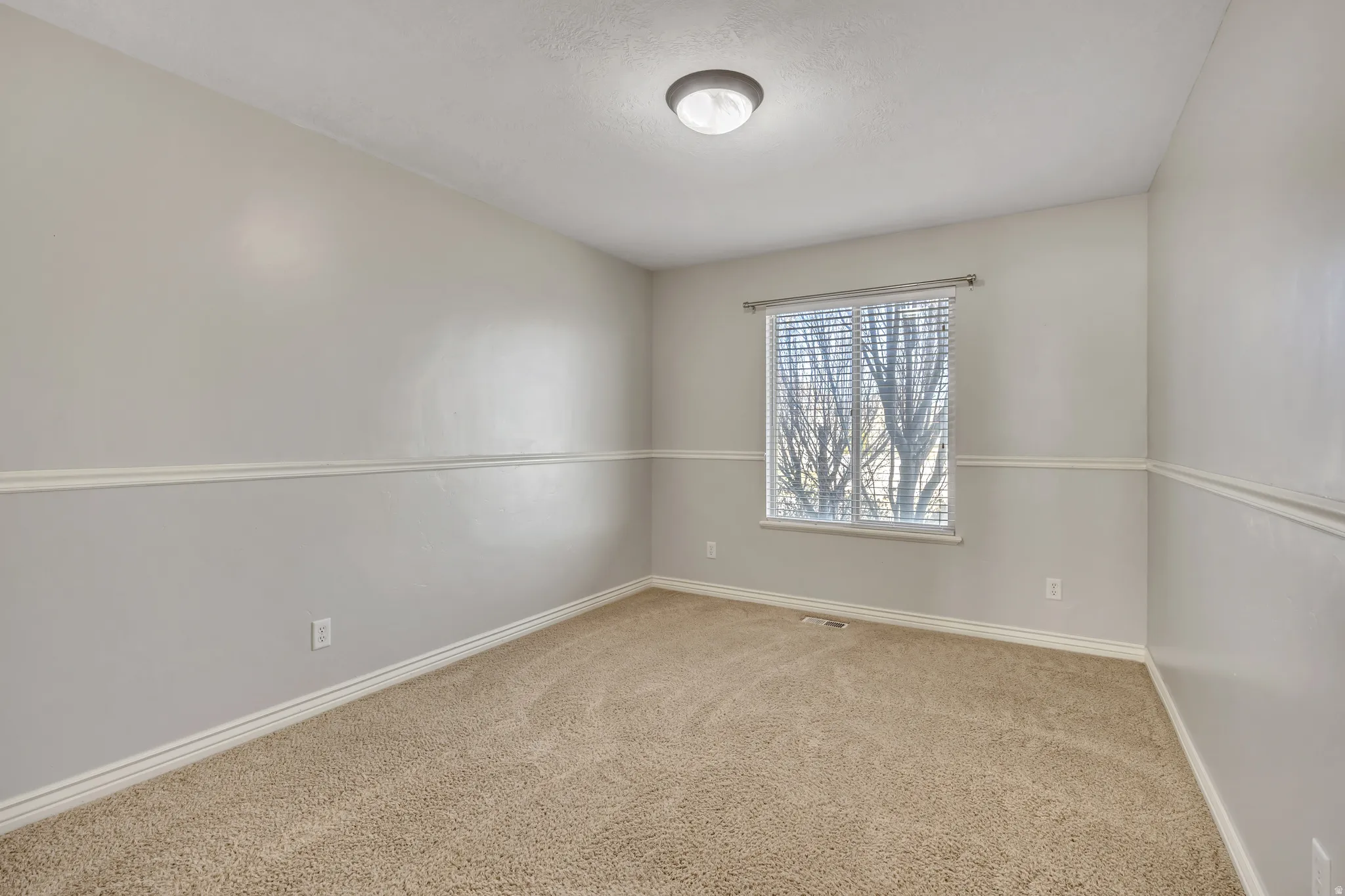 Empty room with light carpet and baseboards
