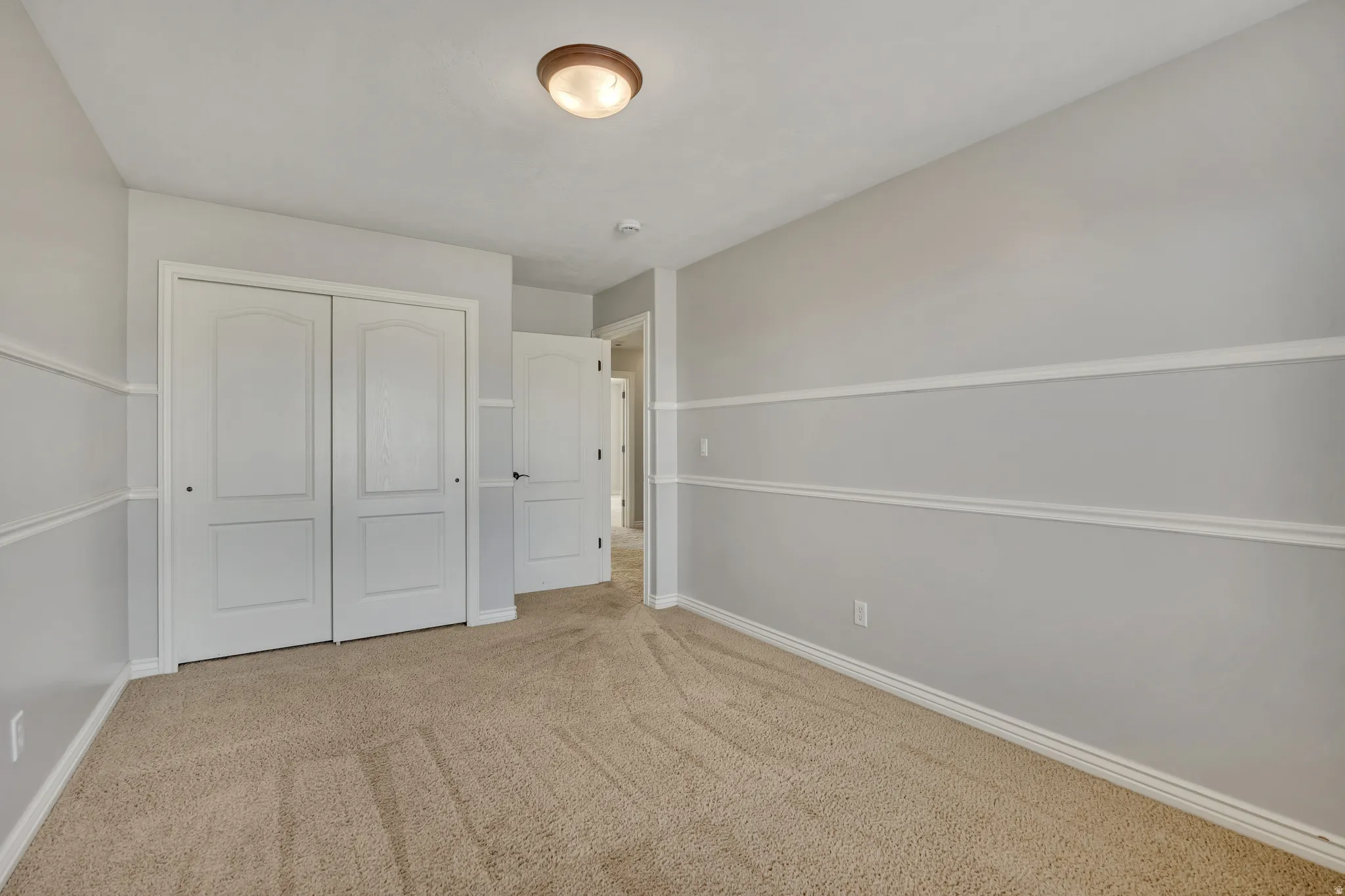 Unfurnished bedroom with a closet and light colored carpet