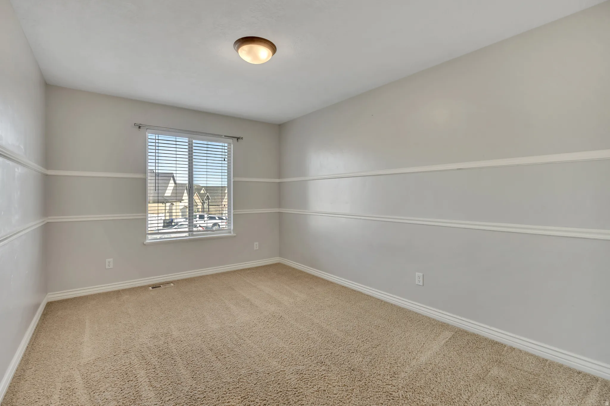 Empty room with light carpet and baseboards