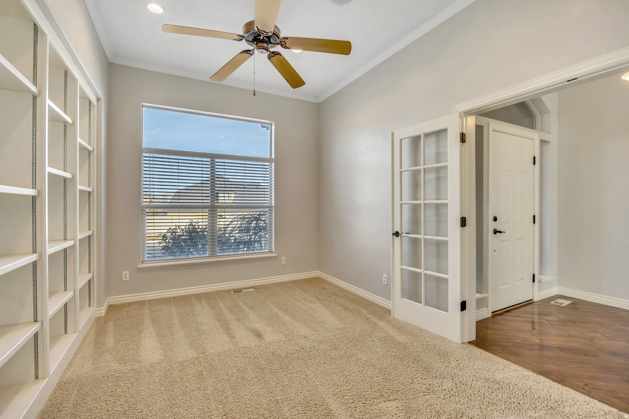 Unfurnished room with light carpet, ornamental molding, and a ceiling fan