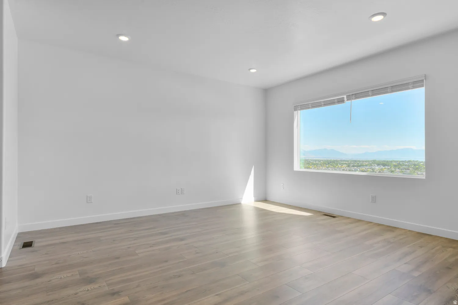Spare room with wood finished floors, recessed lighting, and a mountain view