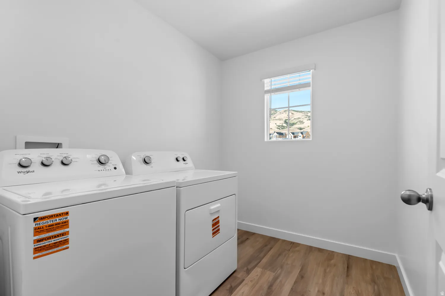Laundry area with light wood-style floors and independent washer and dryer