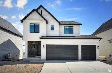 View of front of home with driveway, a garage, and brick siding
