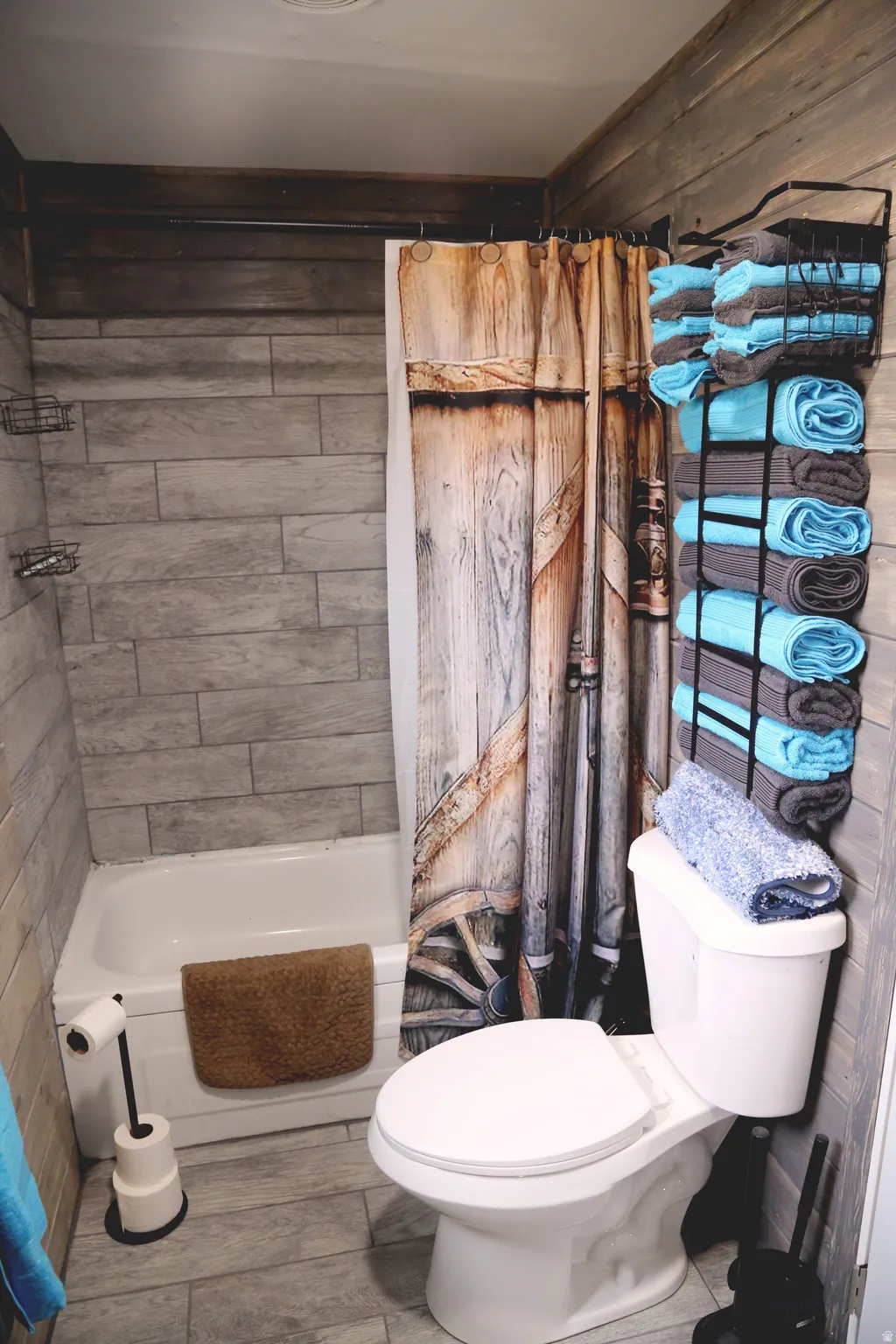 Bathroom featuring shower / tub combo with curtain and wood finished floors