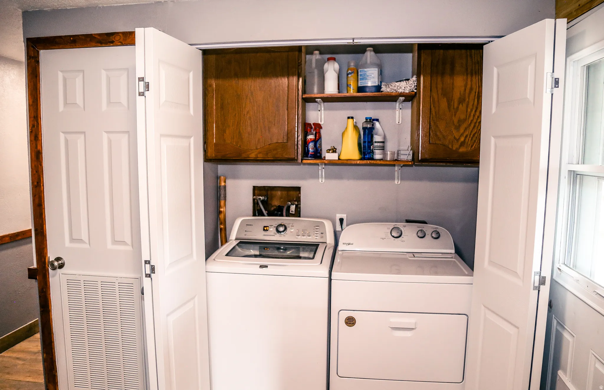 Laundry area featuring independent washer and dryer and cabinet space