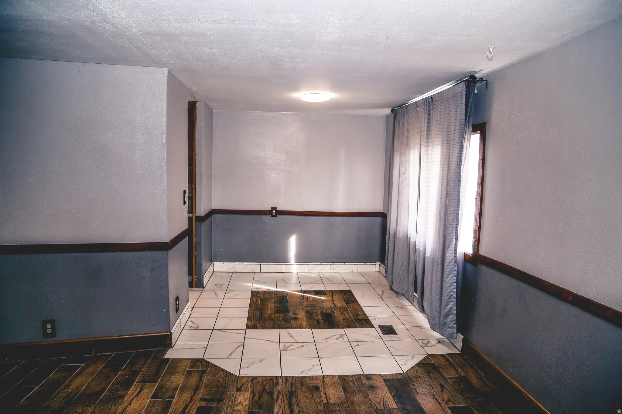 Unfurnished room featuring dark wood finished floors and baseboards