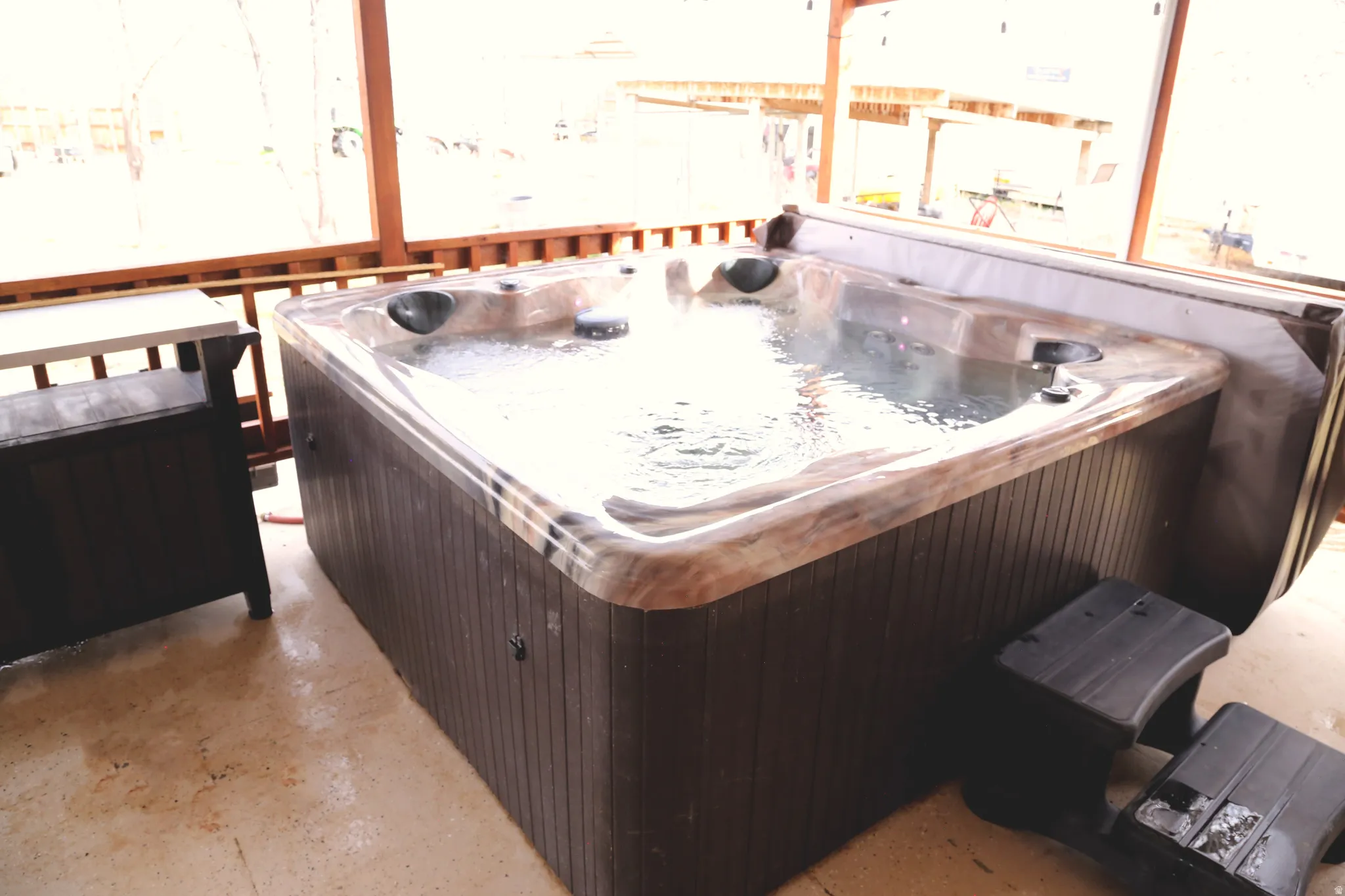 Misc room with a hot tub and concrete floors
